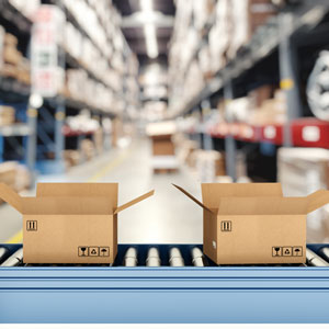 Cardboard boxes on conveyor rollers inside a warehouse ready to be shipped by courier for distribution