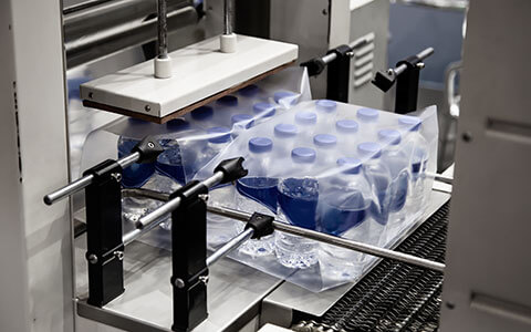 Thermoforming plastic around package of water bottles