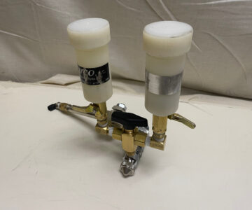 Dual chamber pressure control valve with capped canisters on a white background.