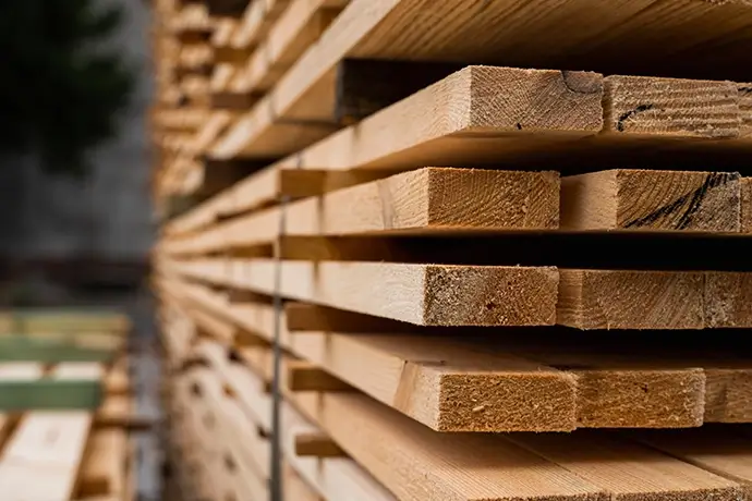 Piles of wooden boards in the sawmill, planking. Warehouse for sawing boards on a sawmill outdoors. Wood timber stack of wooden blanks construction material.